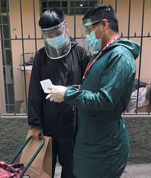 José Luis distributing foodstuffs to recipient.