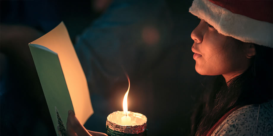 Festive Christmas singer with candle and songbook