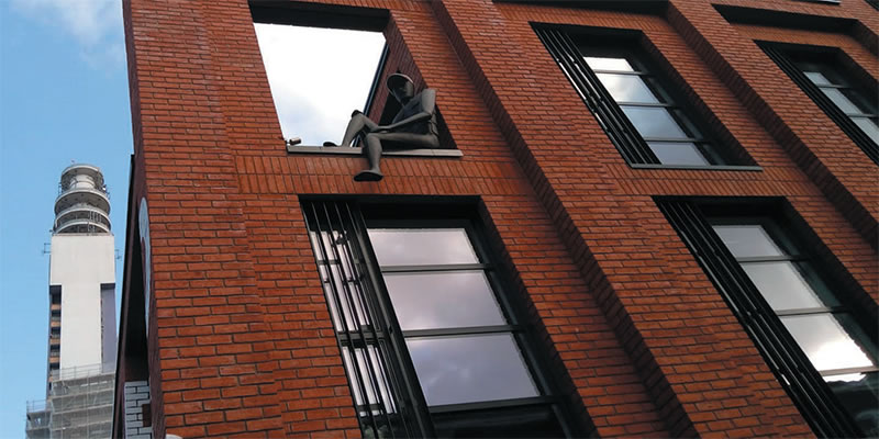 A Peaky Blinders statue on a building