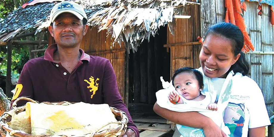 A Subanen crafter carries her baby in a sling.