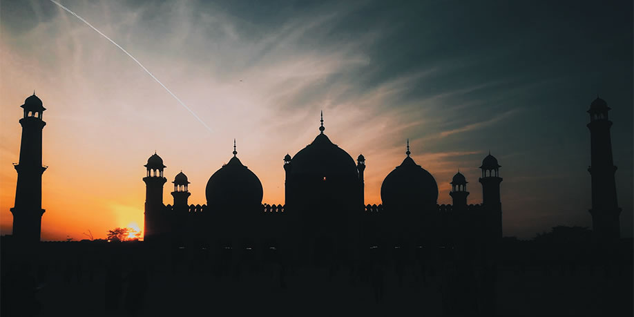 A mosque silhouetted against a setting sun