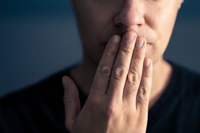 Man with hand across his lips