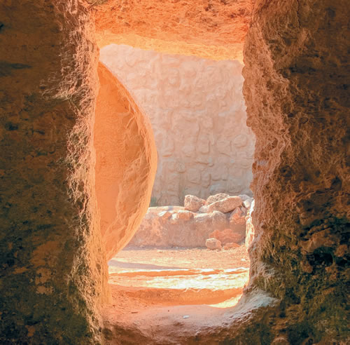 Looking down a stone tunnel with a round rock rolled to the side at the entrance