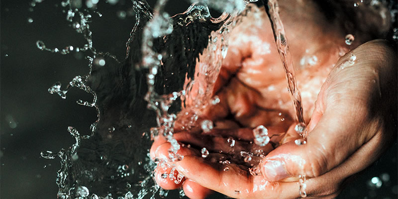 Water running into cupped hands.