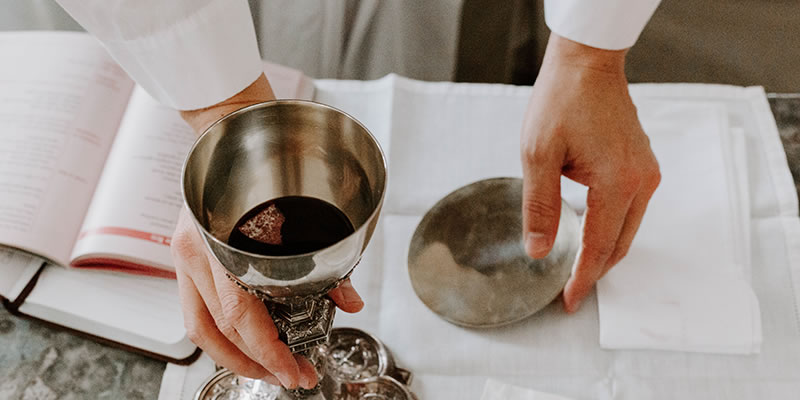 Priest holding the body and blood of Christ during Mass