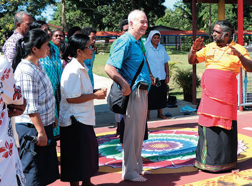 Sangam priest speaking to Fr. Frank and the Catholic group