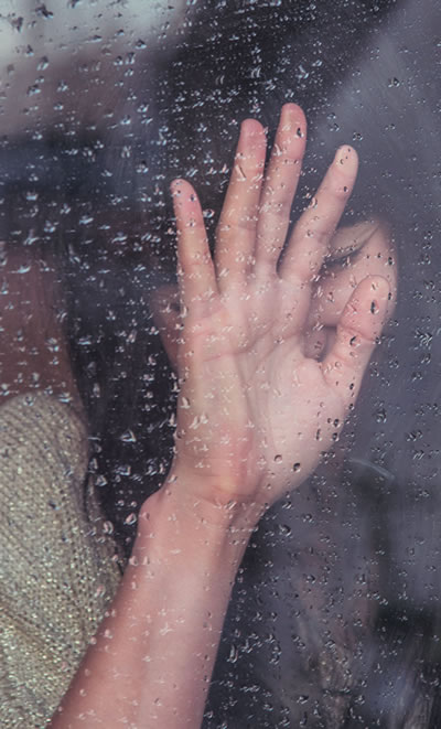 Woman trapped behind a glass barrier