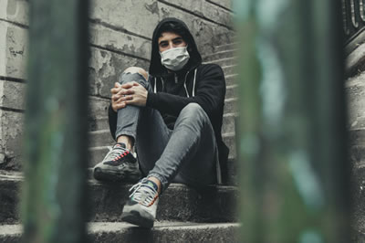 Man with mask sitting on steps