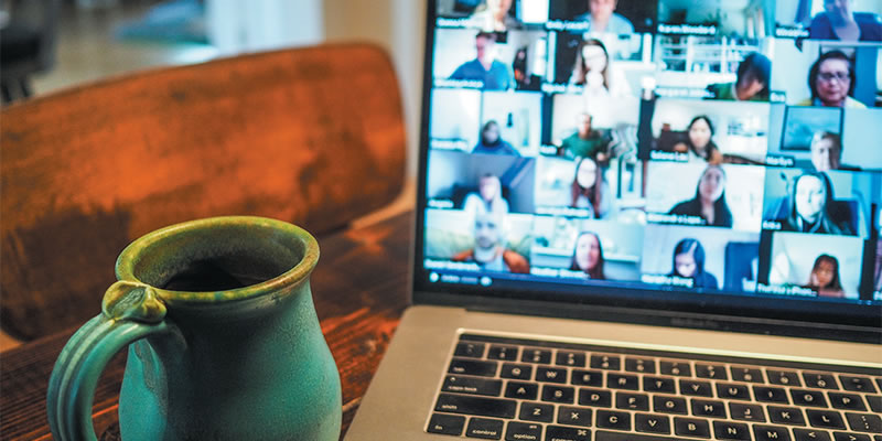 A desktop with an open laptop computer and coffee cup