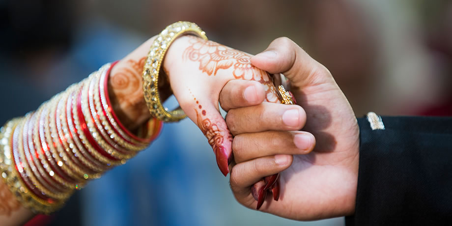 Bride and groom hold hands during Pakistani wedding