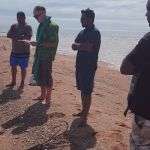 Men lined up on the beach for final prayers.