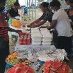 People set up a funeral lunch under a tent