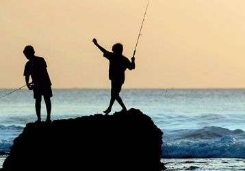 Children fishing from a rock