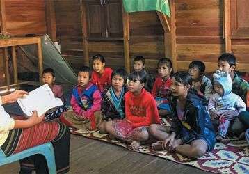 Teacher reading to school children