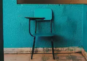 Empty school desk chair in an empty room