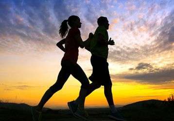 Two people running at sunset